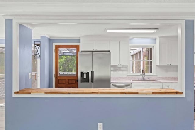 157 Mile Creek Rd, Old Lyme, CT 06371 - kitchen featuring stainless steel fridge with ice dispenser, ornamental molding, butcher block counters, dishwashing machine, and white cabinetry