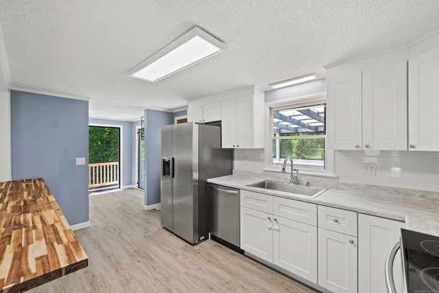 157 Mile Creek Rd, Old Lyme, CT 06371 - kitchen with appliances with stainless steel finishes, light wood-style flooring, light countertops, a textured ceiling, and white cabinetry