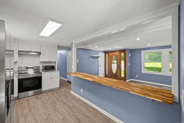 157 Mile Creek Rd, Old Lyme, CT 06371 - kitchen featuring stainless steel appliances, butcher block counters, under cabinet range hood, white cabinets, and light wood finished floors