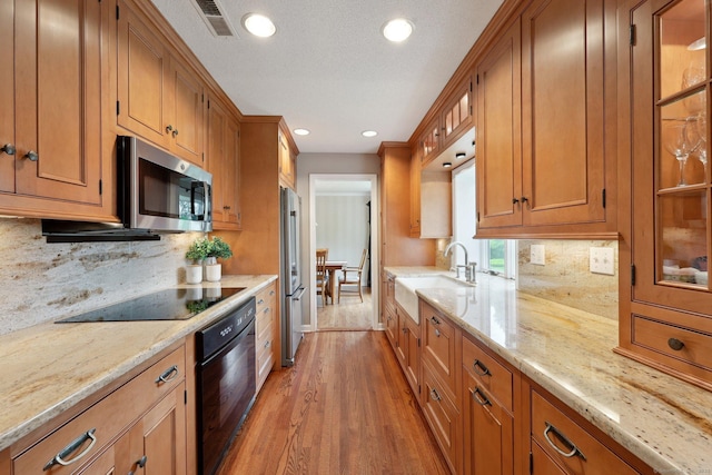 20 Cherry Ln, Madison, CT 06443 - kitchen with black appliances, a sink, brown cabinetry, light wood-type flooring, and recessed lighting