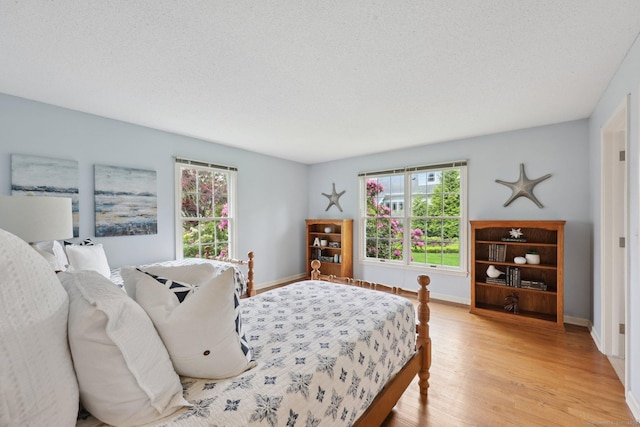 20 Cherry Ln, Madison, CT 06443 - bedroom featuring wood finished floors, multiple windows, baseboards, and a textured ceiling