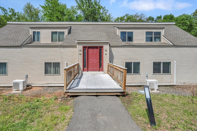 view of front facade with a deck, a shingled roof, and ac unit