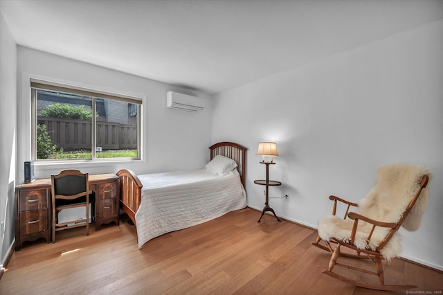 bedroom with a wall mounted AC and light wood-type flooring