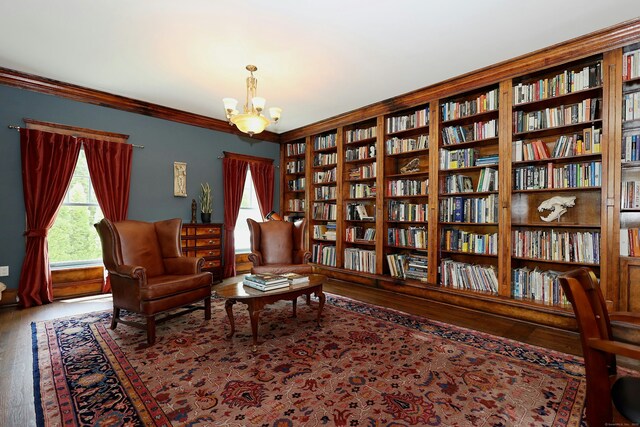 171 Cross Hwy, Redding, CT 06896 - living area featuring wall of books, wood finished floors, plenty of natural light, a chandelier, and crown molding