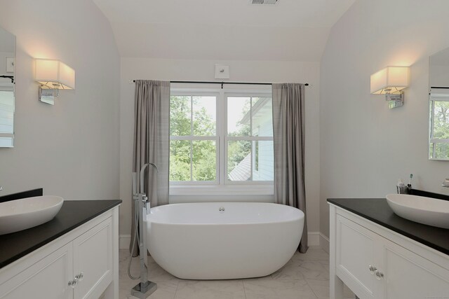 171 Cross Hwy, Redding, CT 06896 - full bath with vanity, marble look tiles, a freestanding tub, baseboards, and vaulted ceiling