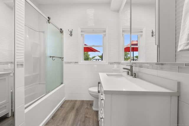 100 Boston Ter, Bridgeport, CT 06610 - full bathroom with vanity, tile walls, wood finished floors, toilet, and bath / shower combo with glass door