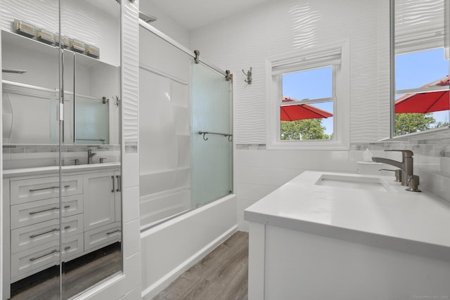 100 Boston Ter, Bridgeport, CT 06610 - bathroom featuring vanity, wood finished floors, bath / shower combo with glass door, healthy amount of natural light, and tile walls