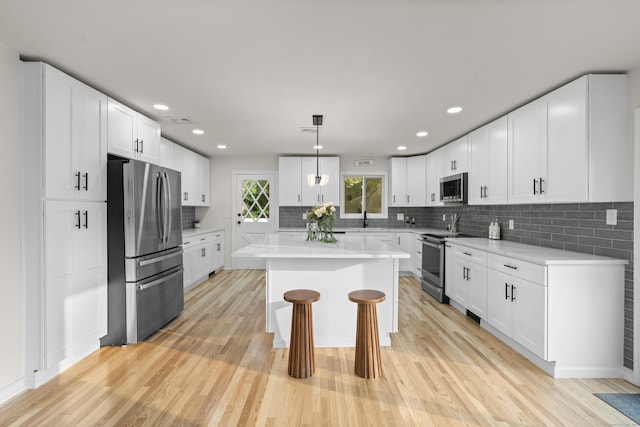 4 Wanzer Hill Rd, Sherman, CT 06784 - kitchen featuring stainless steel appliances, a center island, light wood-style floors, backsplash, and recessed lighting