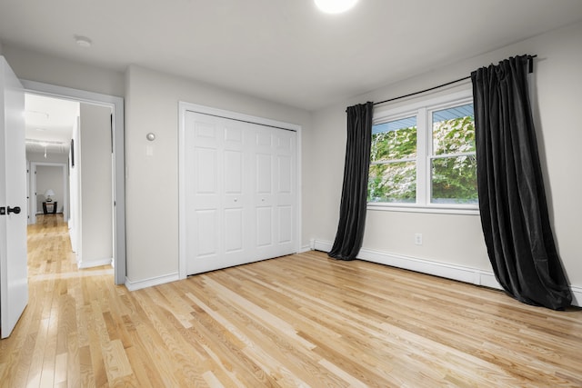 4 Wanzer Hill Rd, Sherman, CT 06784 - unfurnished bedroom with light wood-style flooring, baseboards, a closet, and a baseboard heating unit