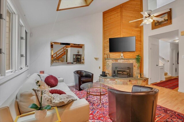424 Trailsend Dr Unit 424, Torrington, CT 06790 - living room with a wood stove, a ceiling fan, wood finished floors, high vaulted ceiling, and stairs