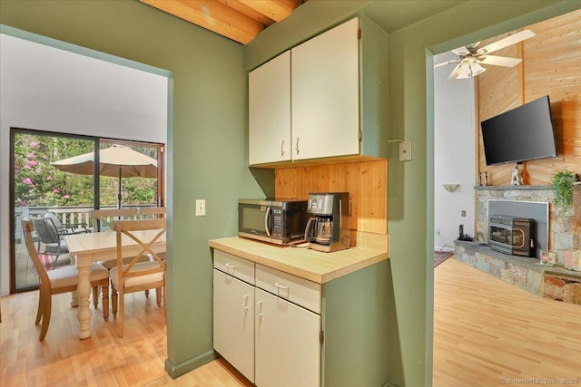 424 Trailsend Dr Unit 424, Torrington, CT 06790 - kitchen with light wood-type flooring, a wood stove, a ceiling fan, and wooden counters