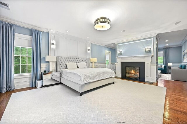 6 Coachlamp Ln, Greenwich, CT 06830 - bedroom featuring ornamental molding, a decorative wall, wood finished floors, a fireplace with flush hearth, and recessed lighting