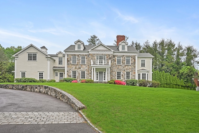 6 Coachlamp Ln, Greenwich, CT 06830 - view of front facade with stone siding, a chimney, a front yard, and a balcony