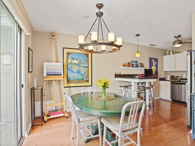 100 Wolfpit Ave Apt 19, Norwalk, CT 06851 - dining area with light wood finished floors, a chandelier, baseboards, and ceiling fan
