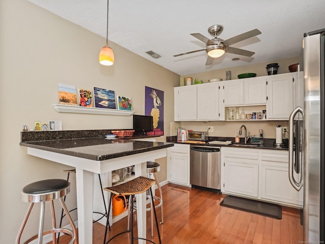 100 Wolfpit Ave Apt 19, Norwalk, CT 06851 - kitchen featuring appliances with stainless steel finishes, a sink, open shelves, and a kitchen breakfast bar
