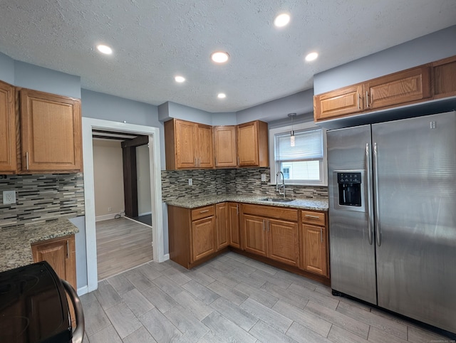26 Westfield St, Manchester, CT 06042 - kitchen featuring stainless steel refrigerator with ice dispenser, a sink, decorative backsplash, brown cabinets, and recessed lighting