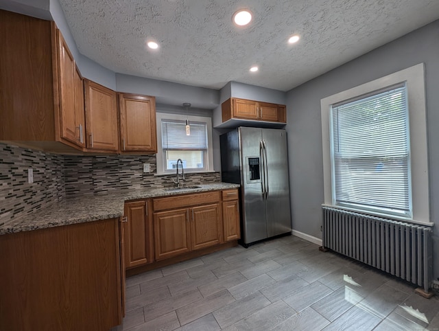 26 Westfield St, Manchester, CT 06042 - kitchen featuring radiator heating unit, stainless steel fridge, a sink, brown cabinets, and backsplash