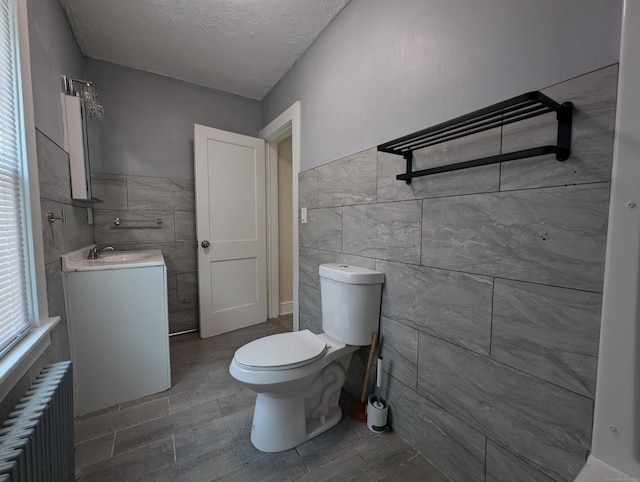 26 Westfield St, Manchester, CT 06042 - bathroom featuring tile walls, radiator, toilet, vanity, and a textured ceiling