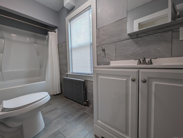 26 Westfield St, Manchester, CT 06042 - bathroom with radiator heating unit, tile walls, toilet, vanity, and shower / bath combination with curtain