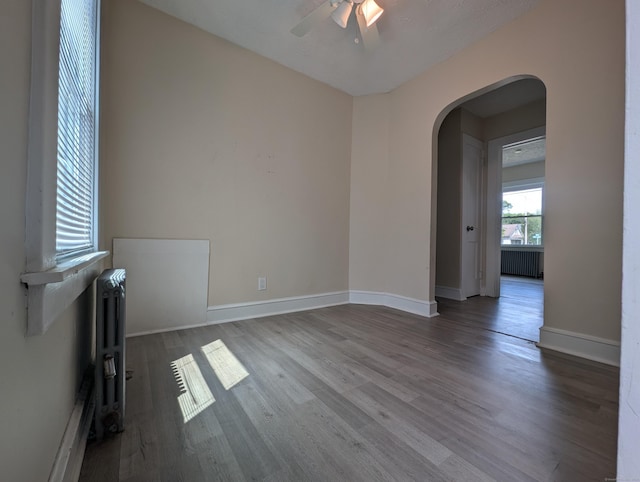 26 Westfield St, Manchester, CT 06042 - empty room featuring arched walkways, a ceiling fan, wood finished floors, radiator, and baseboards