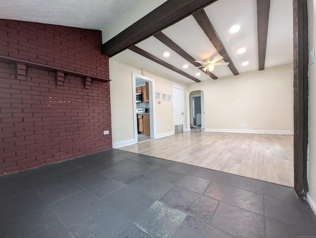 26 Westfield St, Manchester, CT 06042 - empty room with arched walkways, beamed ceiling, brick wall, recessed lighting, and baseboards