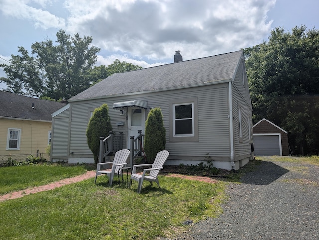 26 Westfield St, Manchester, CT 06042 - bungalow featuring a front lawn, a chimney, roof with shingles, a detached garage, and an outdoor structure
