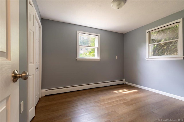 270 S Windham Rd Apt 61, Windham, CT 06226 - unfurnished bedroom featuring a baseboard radiator, wood finished floors, baseboards, and a closet