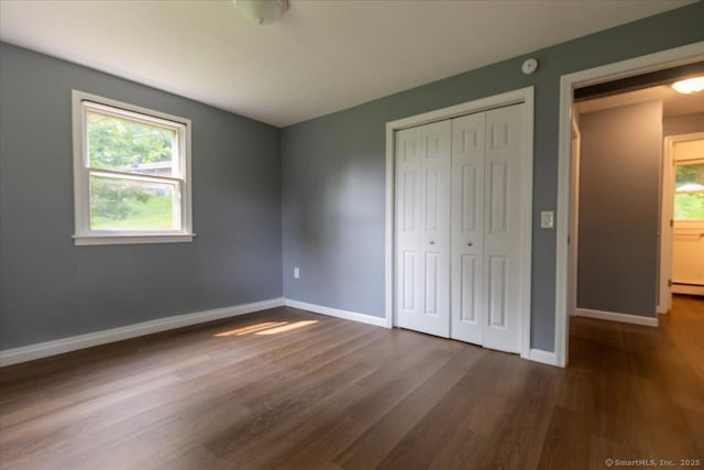 270 S Windham Rd Apt 61, Windham, CT 06226 - unfurnished bedroom featuring dark wood-type flooring, baseboards, and a closet