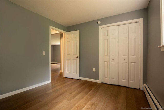 270 S Windham Rd Apt 61, Windham, CT 06226 - unfurnished bedroom with a baseboard radiator, wood finished floors, baseboards, and a closet