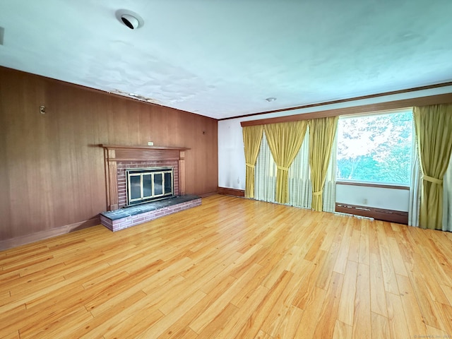 909 Randolph Rd, Middletown, CT 06457 - unfurnished living room featuring wood finished floors, a brick fireplace, wood walls, and baseboards