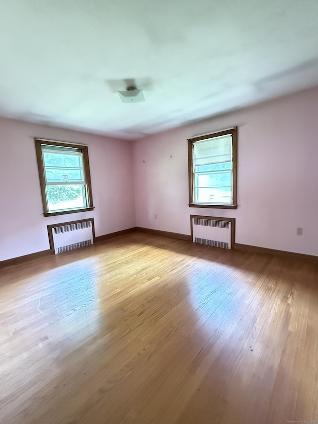 909 Randolph Rd, Middletown, CT 06457 - empty room featuring radiator, plenty of natural light, and light wood finished floors