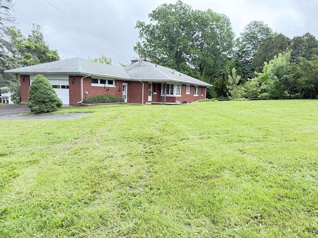 909 Randolph Rd, Middletown, CT 06457 - view of front of home with an attached garage, asphalt driveway, brick siding, and a front yard
