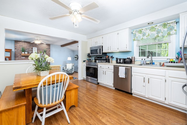 825 Copper Hill Rd, Suffield, CT 06093 - kitchen with appliances with stainless steel finishes, ceiling fan, a sink, light wood-style floors, and white cabinets