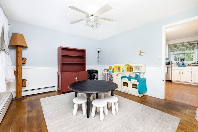 825 Copper Hill Rd, Suffield, CT 06093 - playroom featuring a wainscoted wall, baseboard heating, wood finished floors, and ceiling fan