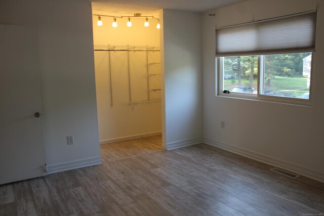 9 Watch Hill Cir Unit 9, Cromwell, CT 06416 - unfurnished bedroom with wood finished floors, a spacious closet, and baseboards