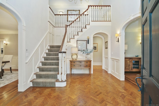 19 Father Peters Ln, New Canaan, CT 06840 - entryway with a decorative wall, stairway, a high ceiling, arched walkways, and ornamental molding
