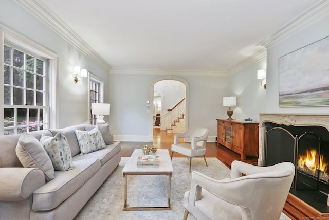 19 Father Peters Ln, New Canaan, CT 06840 - living area featuring arched walkways, a high end fireplace, ornamental molding, wood finished floors, and stairs
