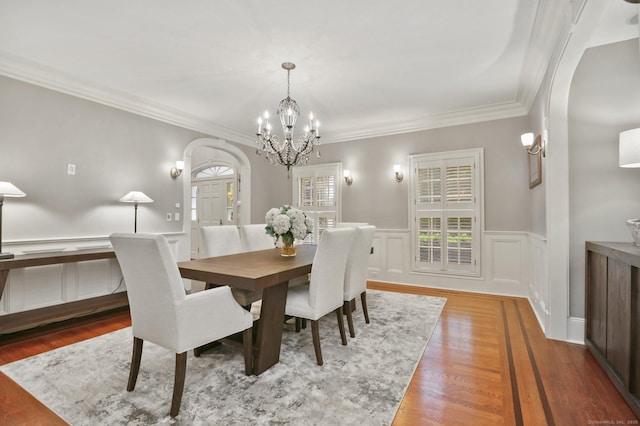 19 Father Peters Ln, New Canaan, CT 06840 - dining area featuring arched walkways, a chandelier, healthy amount of natural light, ornamental molding, and a wainscoted wall