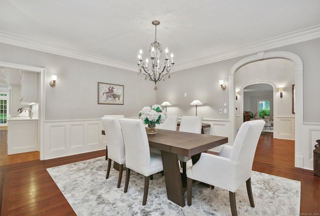 19 Father Peters Ln, New Canaan, CT 06840 - dining space featuring arched walkways, healthy amount of natural light, crown molding, wood finished floors, and a decorative wall