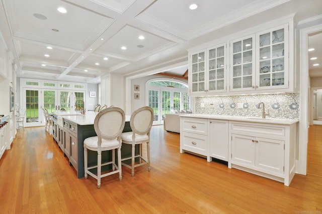 19 Father Peters Ln, New Canaan, CT 06840 - kitchen with french doors, coffered ceiling, white cabinets, light wood-style flooring, and light countertops