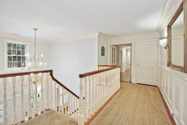 19 Father Peters Ln, New Canaan, CT 06840 - hallway with an upstairs landing, a chandelier, a decorative wall, crown molding, and wainscoting