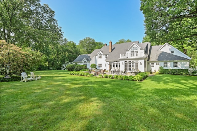 19 Father Peters Ln, New Canaan, CT 06840 - back of property featuring french doors, a yard, a patio, a chimney, and a balcony