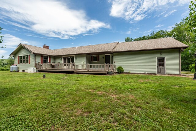 192 Palmer Rd, Chaplin, CT 06235 - back of property with a wooden deck, a lawn, a chimney, and roof with shingles