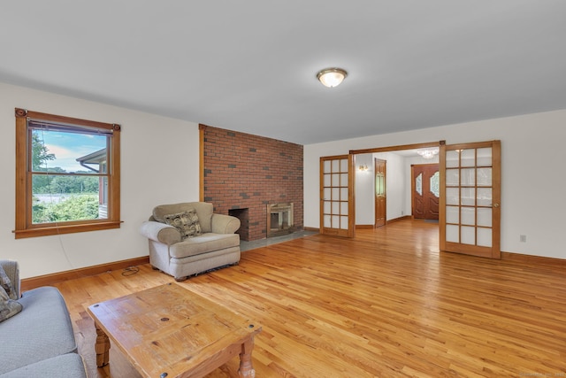 192 Palmer Rd, Chaplin, CT 06235 - living room with light wood finished floors, a brick fireplace, and french doors