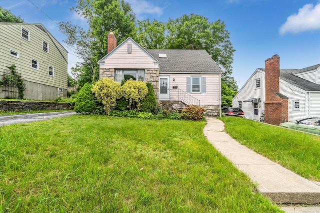 214 Thames St, New London, CT 06320 - view of front of property with stone siding, a front yard, and a chimney