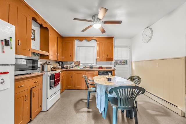 214 Thames St, New London, CT 06320 - kitchen with white appliances, baseboard heating, a wainscoted wall, a ceiling fan, and light countertops