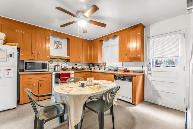 214 Thames St, New London, CT 06320 - kitchen featuring white appliances, a ceiling fan, light countertops, brown cabinets, and a sink
