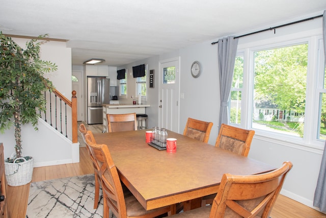 158 Jones Dr, New Britain, CT 06053 - dining area with light wood-style flooring, baseboards, and stairs