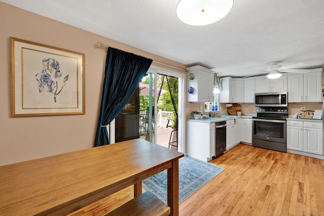 61 Pine Rd, Suffield, CT 06093 - kitchen featuring stainless steel appliances, light countertops, white cabinetry, and light wood-style floors