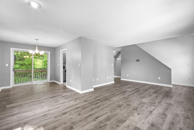 601 Whetstone Mls Unit 601, Killingly, CT 06241 - unfurnished living room with a chandelier, baseboards, and wood finished floors
